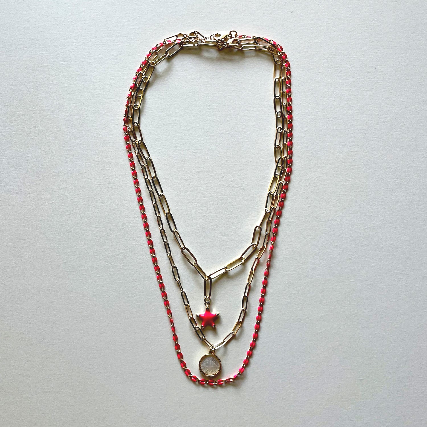 The white Saint Benedict and pink star necklaces