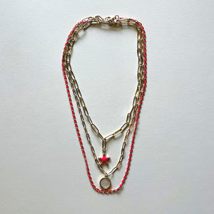 The white Saint Benedict and pink star necklaces