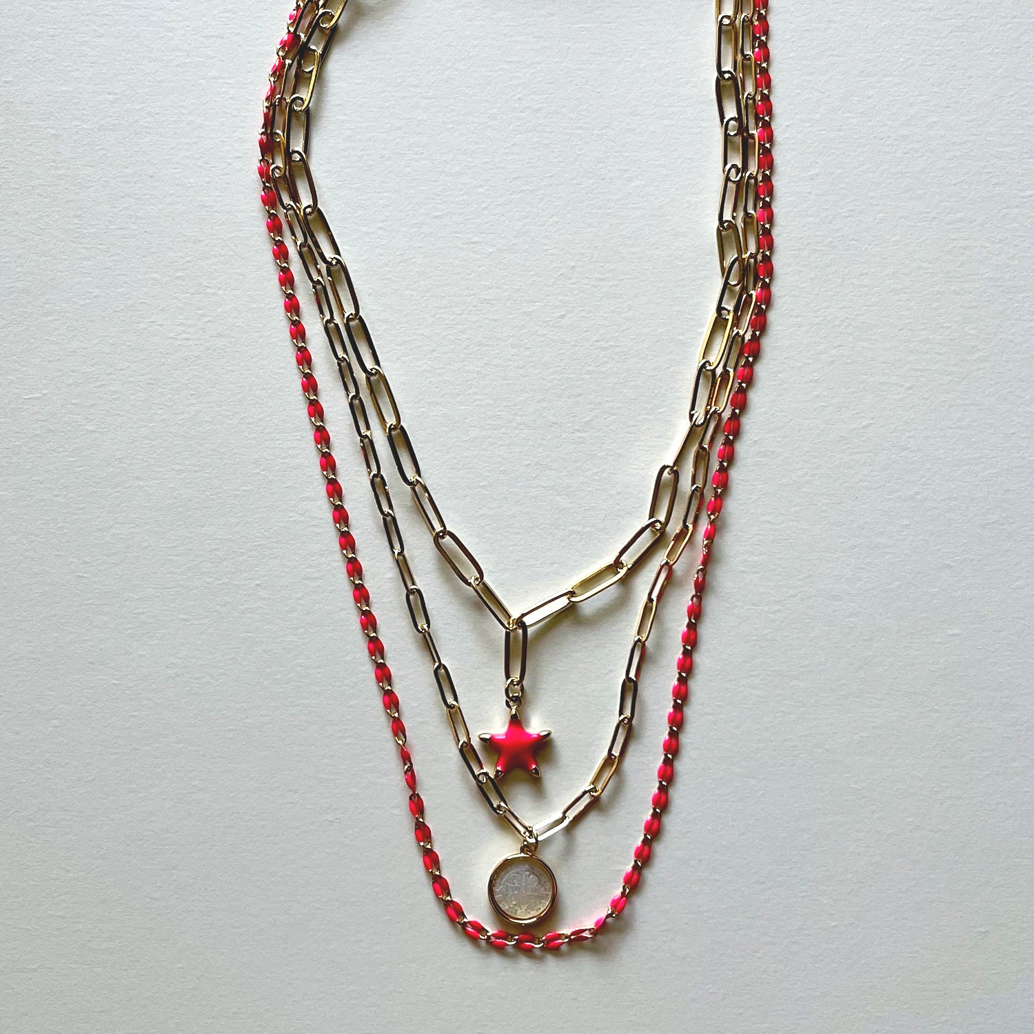 The white Saint Benedict and pink star necklaces