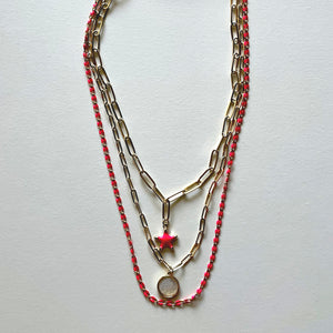 The white Saint Benedict and pink star necklaces