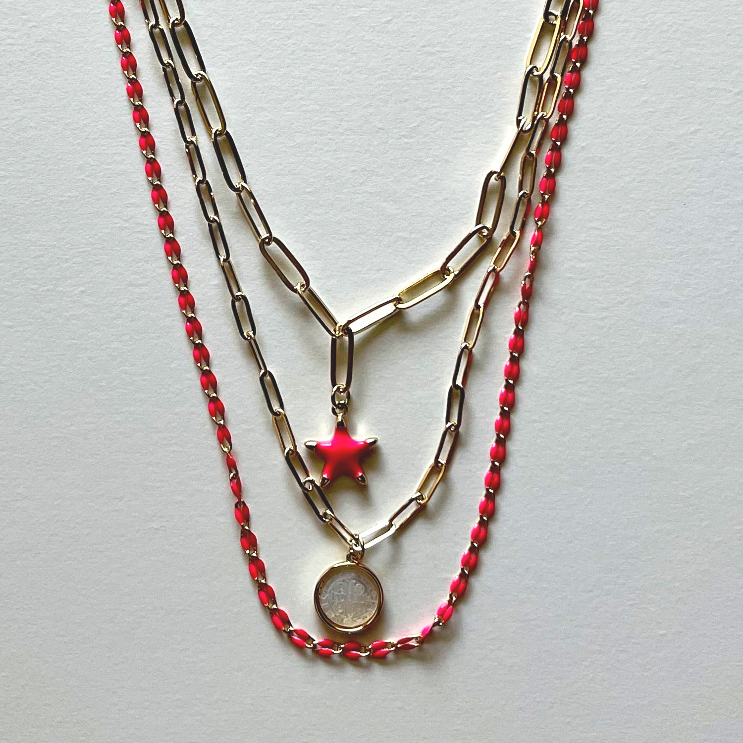 The white Saint Benedict and pink star necklaces